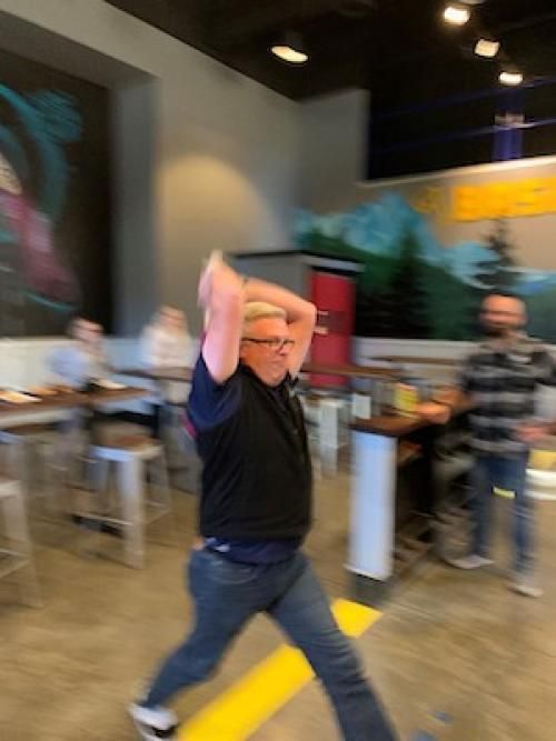 A man in a black shirt is throwing a frisbee in a restaurant