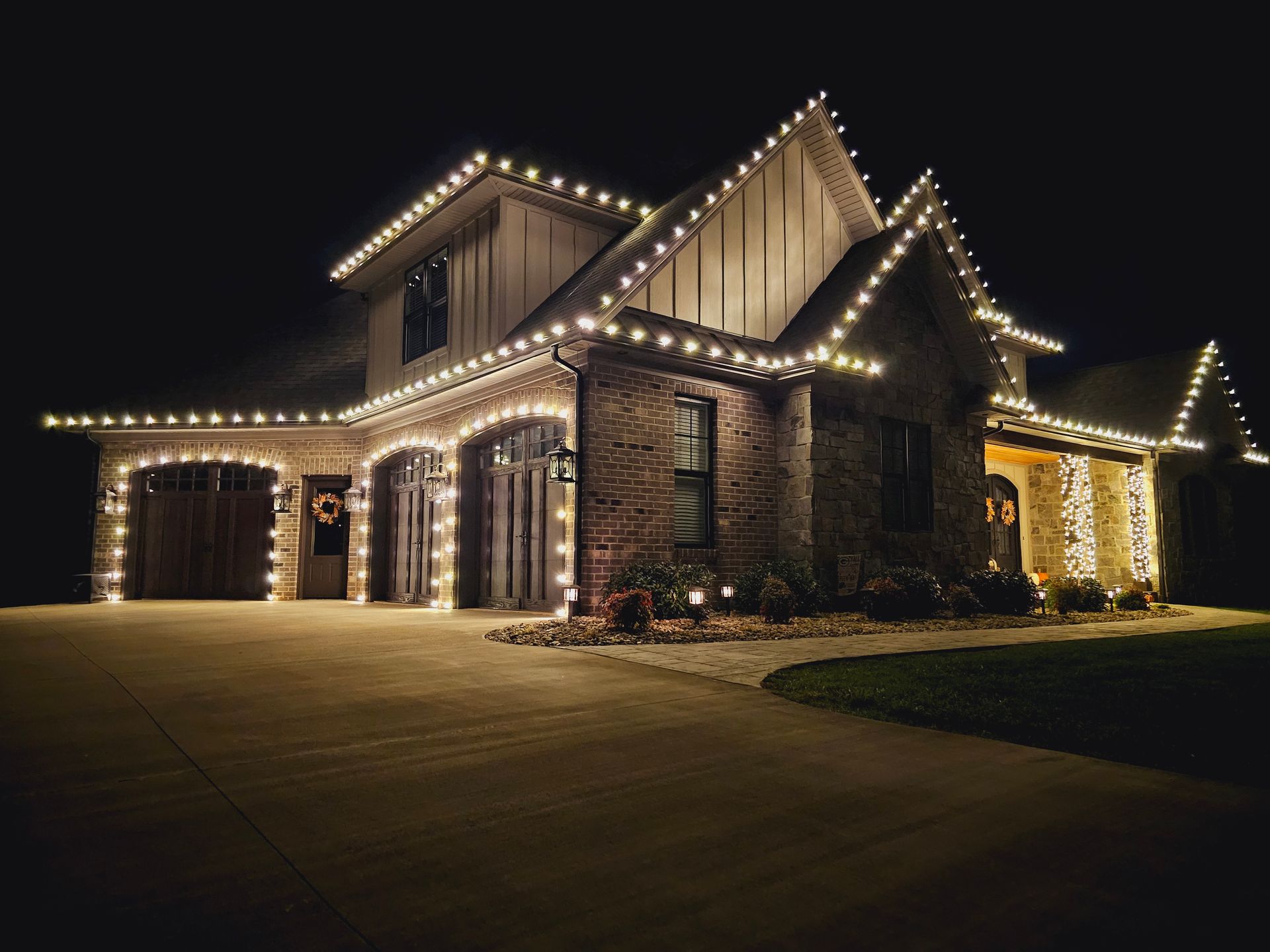 House decorated with white Christmas lights at night.