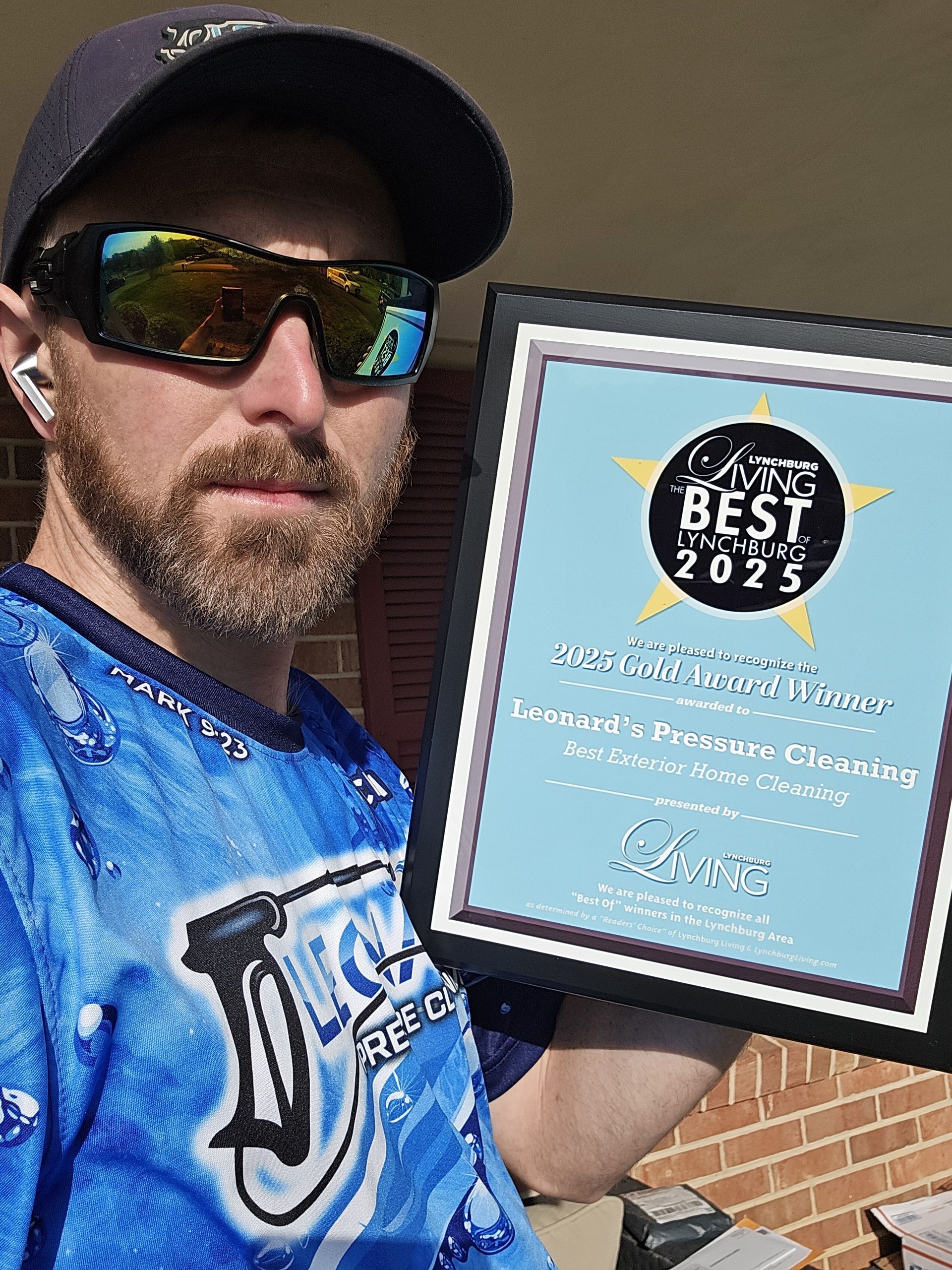 Man in sunglasses holding award plaque.