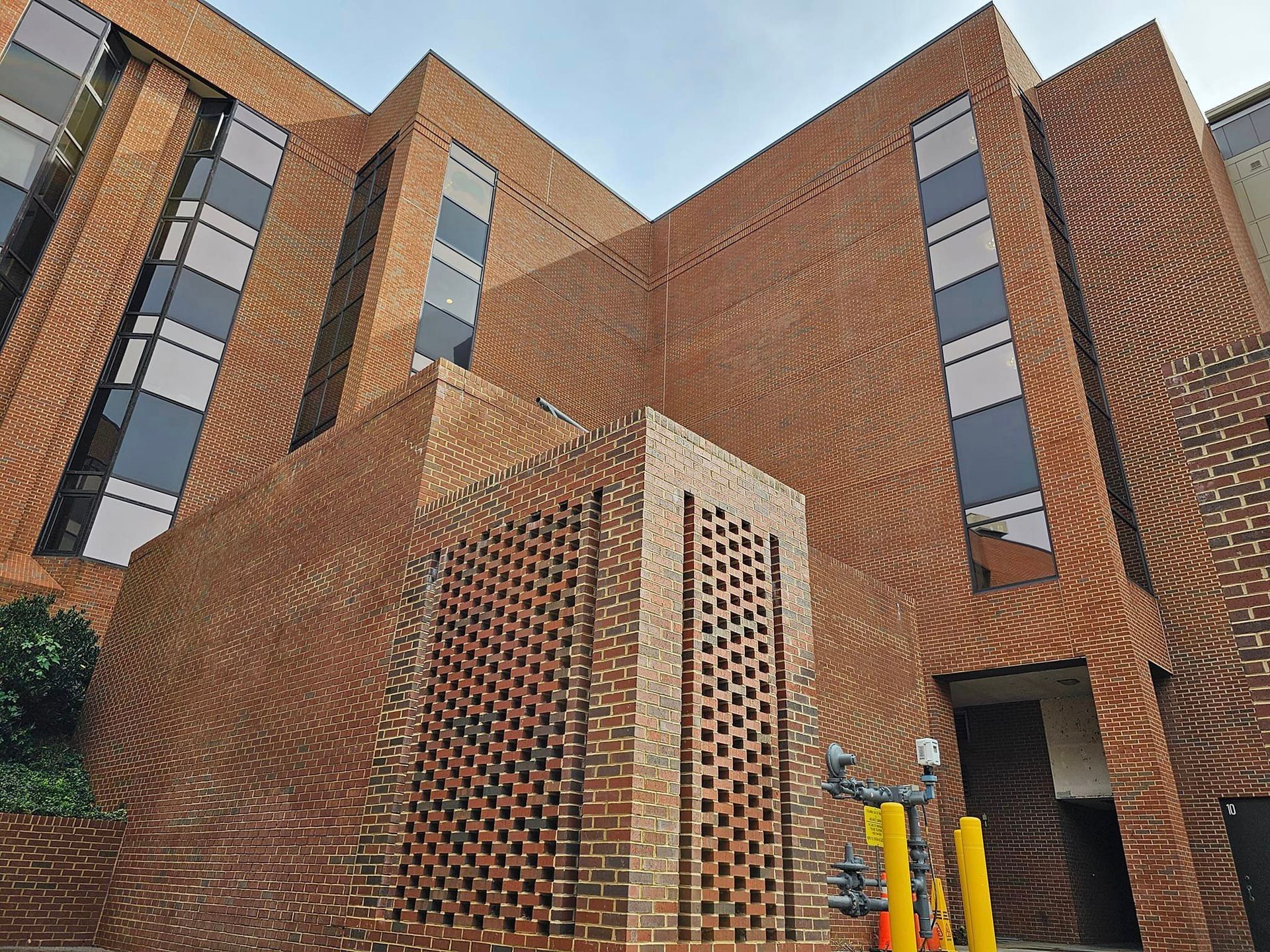 Brick building with rectangular windows and a textured facade; exterior shot.