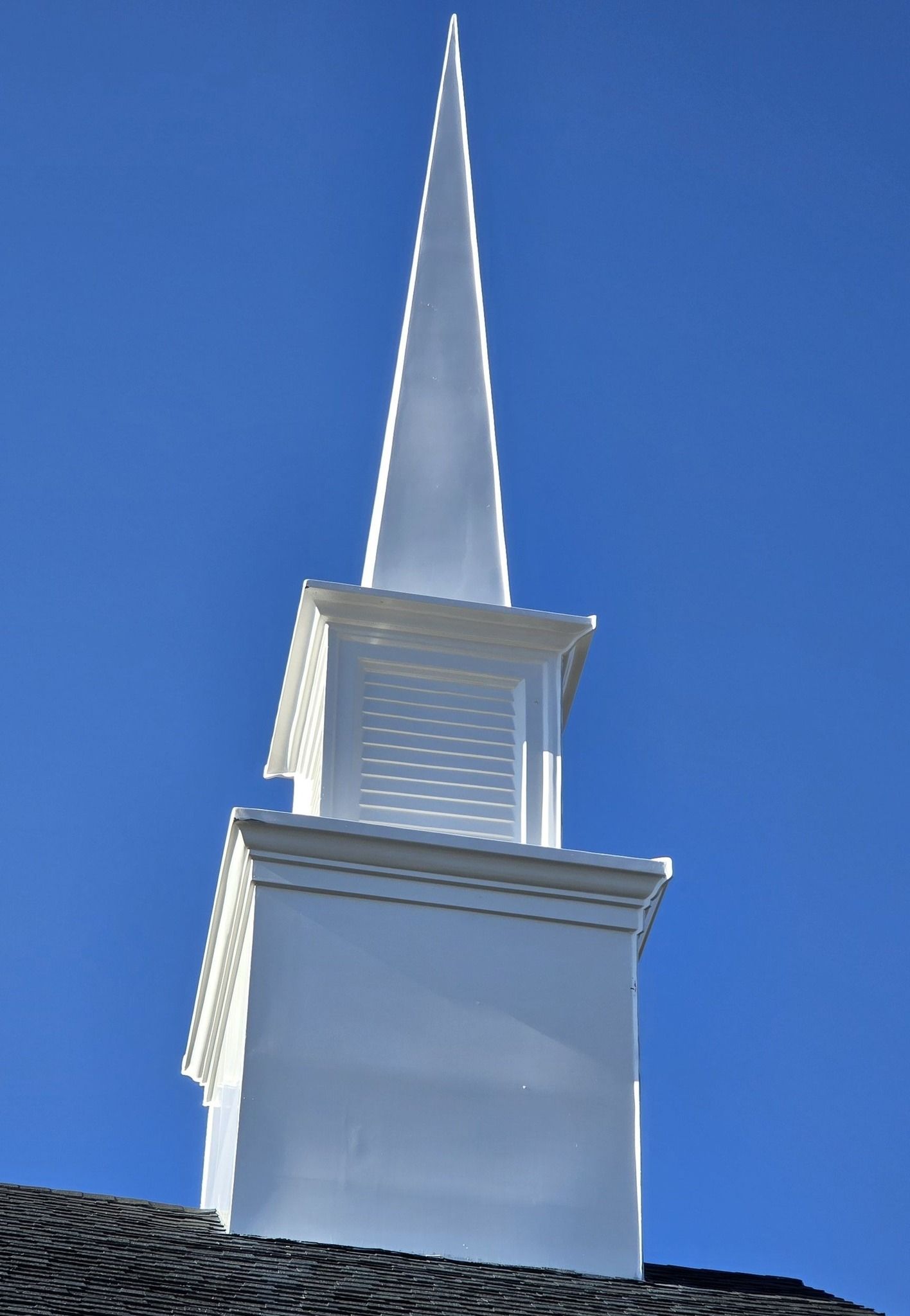 White church steeple against a clear blue sky.