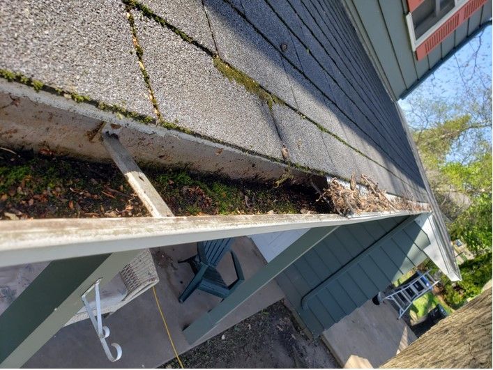 Gutters filled with debris on a house roof.