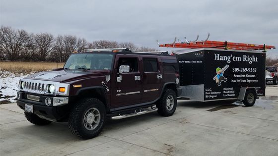 Dark red Hummer towing a black trailer with