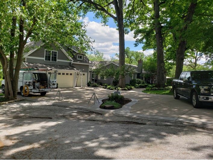 Two-story gray house with a truck parked in the driveway; a landscaping project is underway.