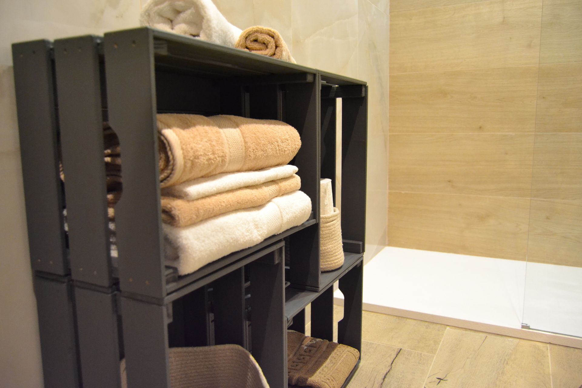 Scaffale nero con asciugamani piegati in un bagno o spa beige