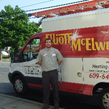 A man stands in front of a heating and cooling van