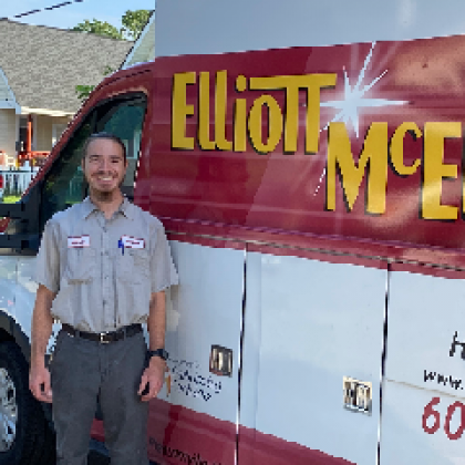A man is standing in front of an Elliott-Mcelwee van