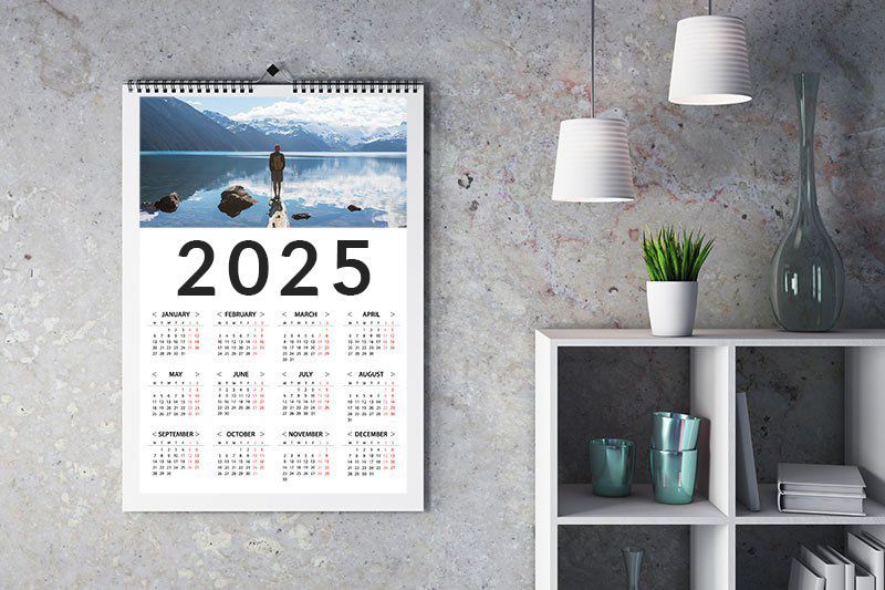 2025 Calendar on grey wall surrounded by decorations.