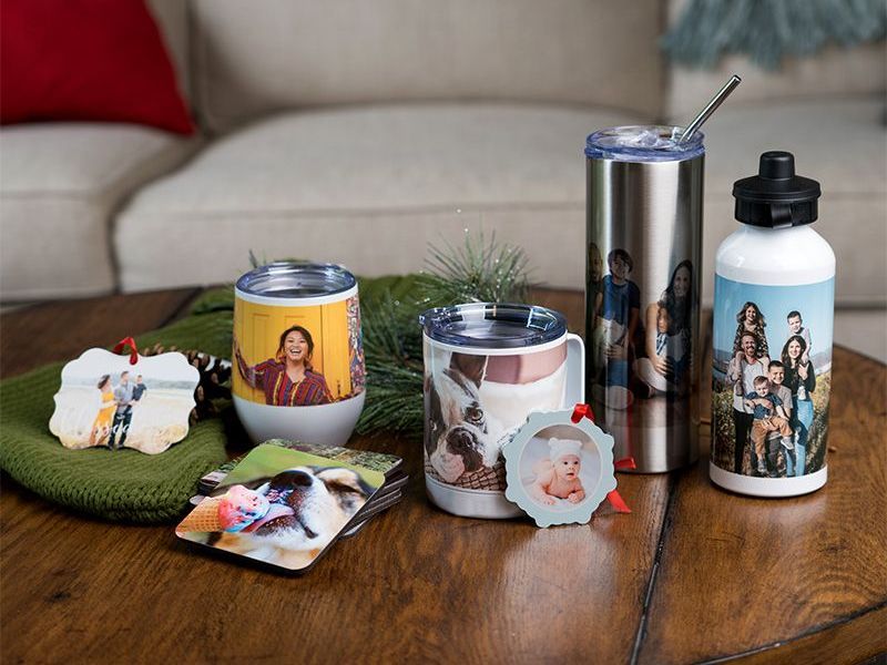 Creative photo gifts of ornaments, coasters, mugs, tumblers, water bottles on wooden table
