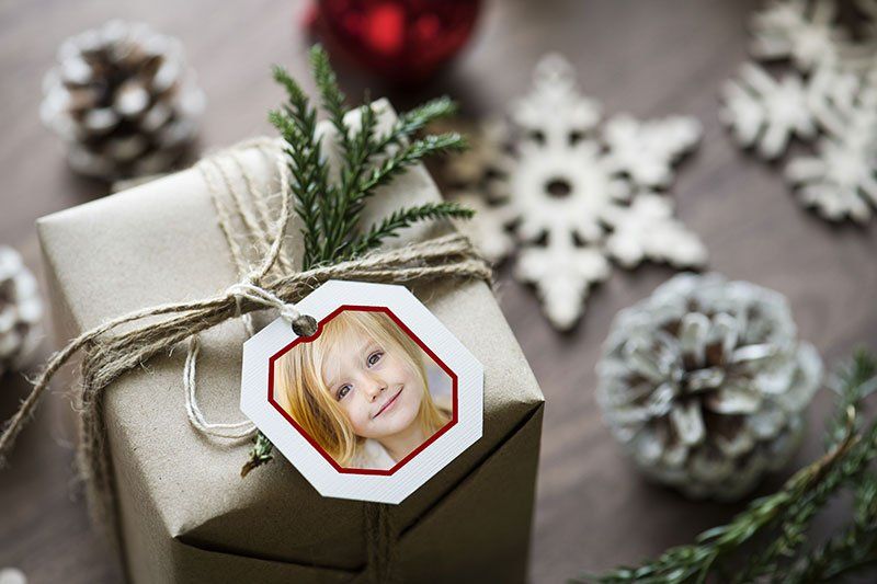 Ornament of little girl sitting on top of present