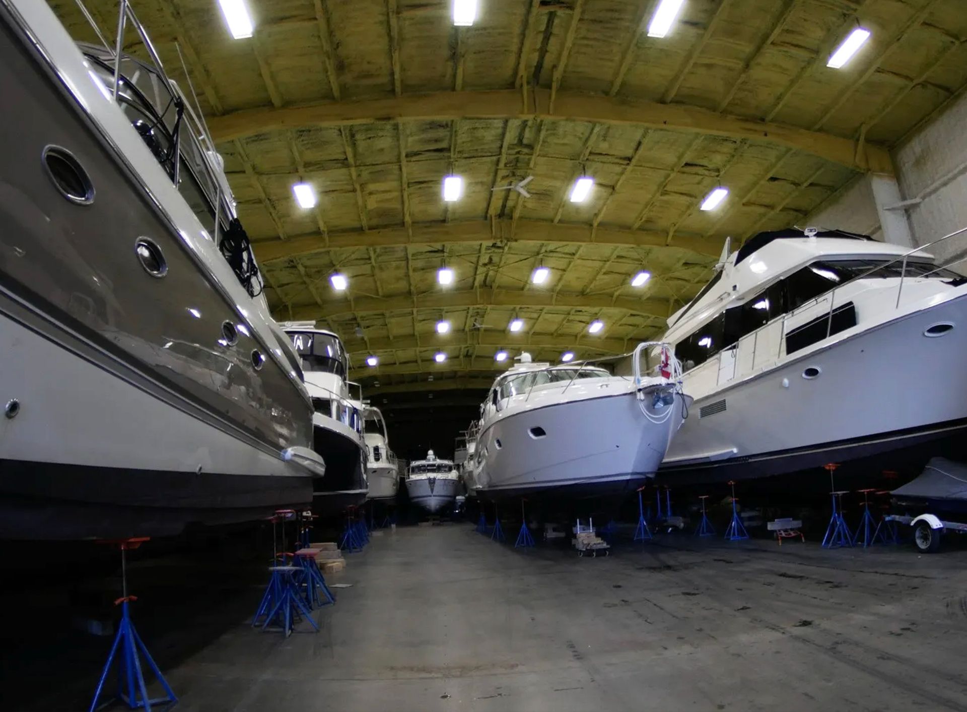 A row of boats are lined up in a warehouse.