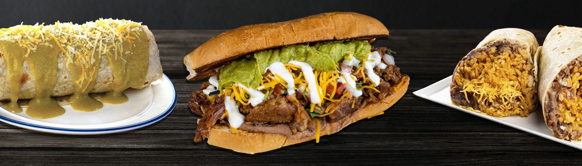 Sandwich, two burritos, and a covered burrito on a plate, all food items on a dark wooden surface.