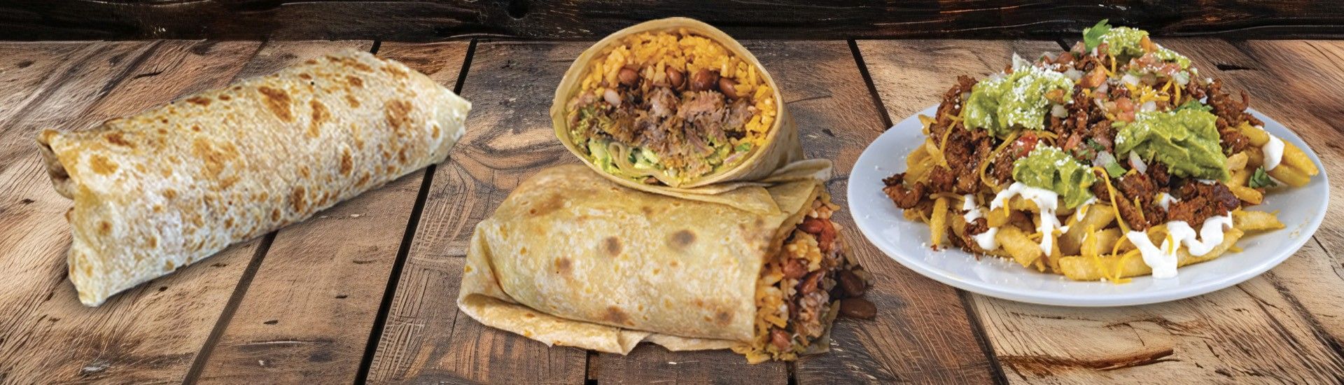 Burritos and loaded nachos on a rustic wooden table.