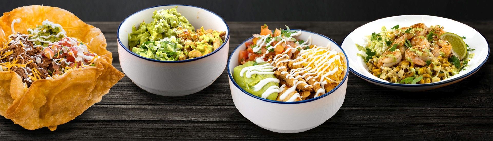 Assortment of bowls with different food. On a wooden table. The bowls contain different ingredients.