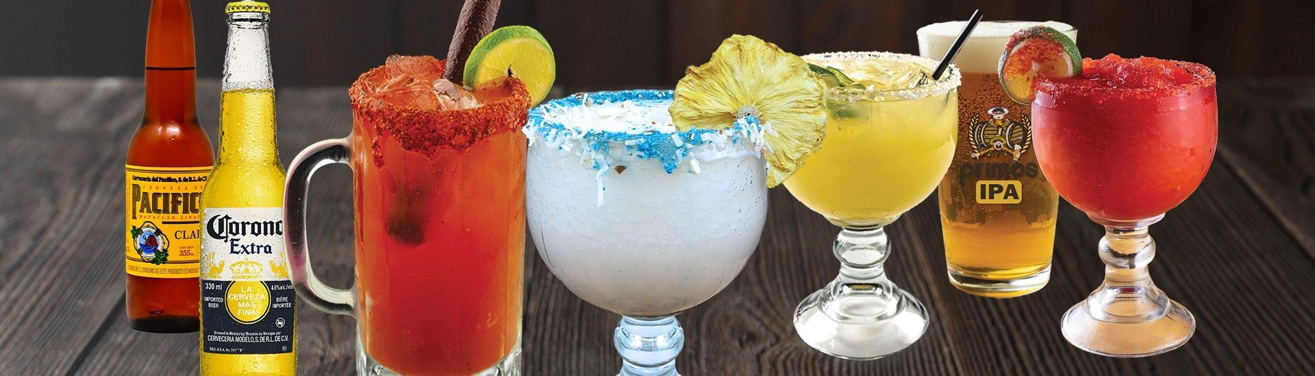 Various colorful alcoholic beverages on a wooden surface, including beer and cocktails with fruit garnishes.