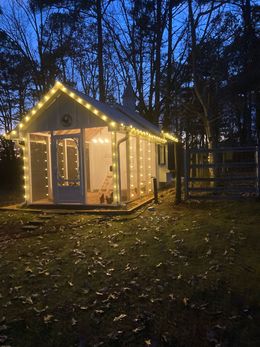 A small white house with christmas lights on it