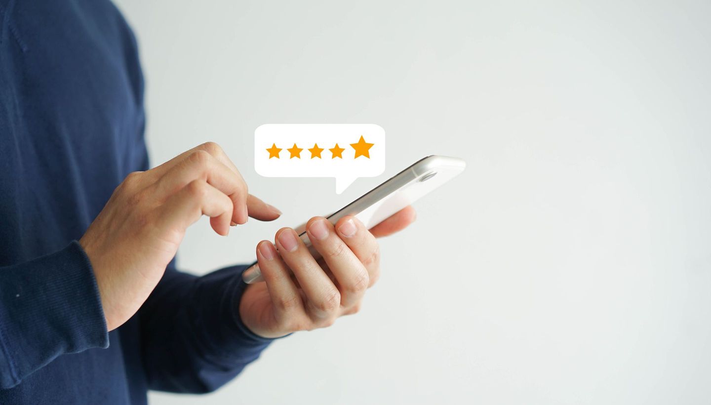 A person is holding a cell phone with a speech bubble with a star on it.
