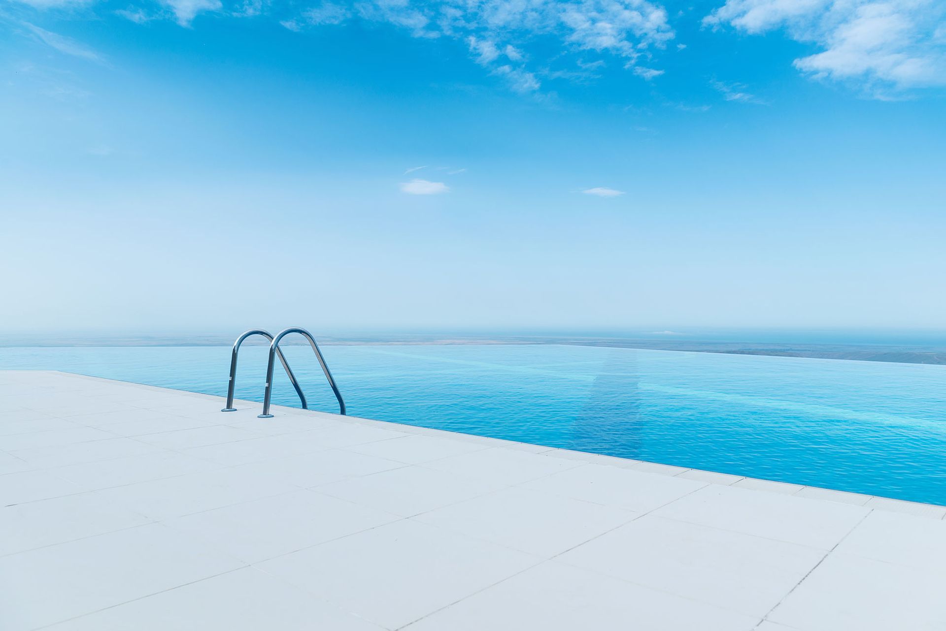 Infinity pool overlooking the ocean under a clear blue sky.