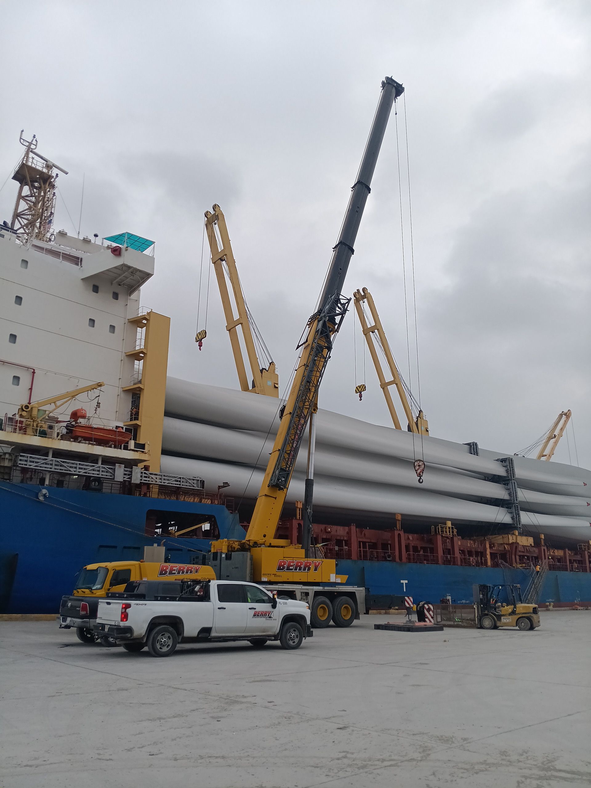 A truck is parked in front of a large ship