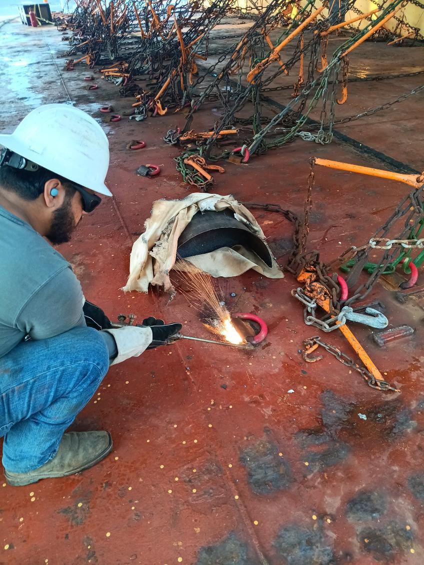 A man wearing a welding helmet is using a welding torch