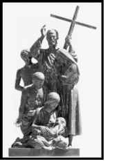 Statue of three figures, one holding a large cross, in a solemn religious scene