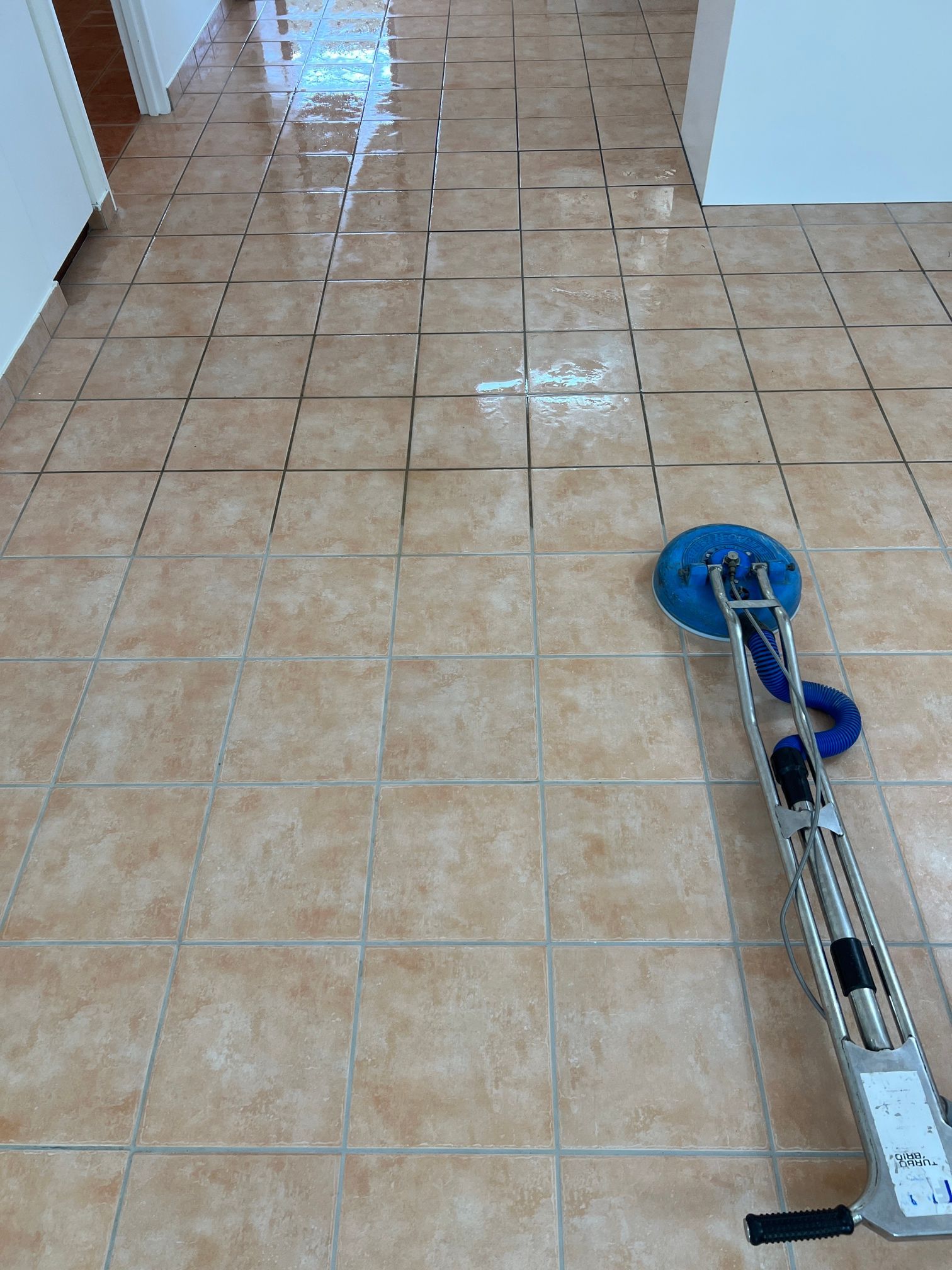 A cleaning machine is sitting on a tiled floor.