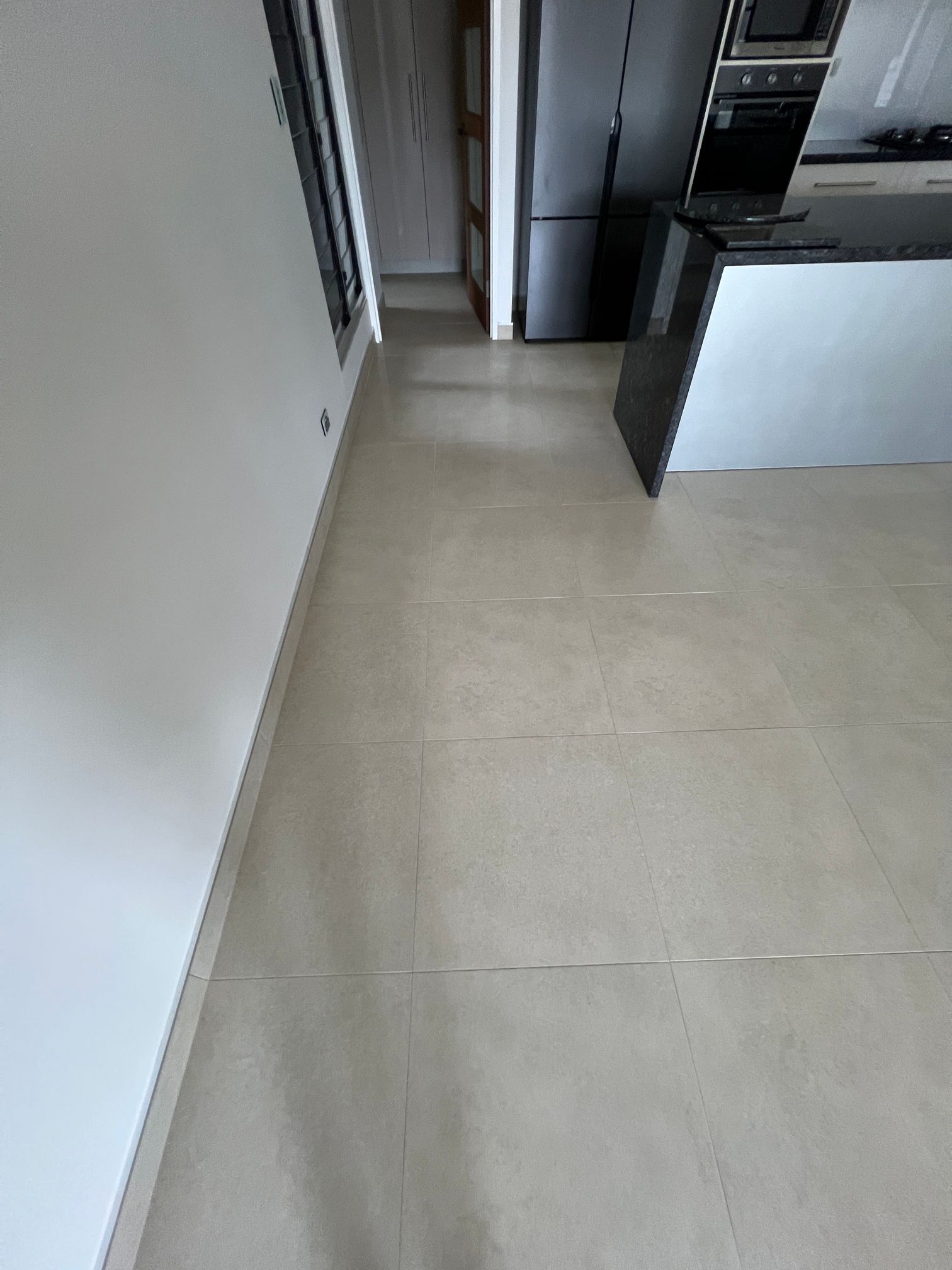 A kitchen with a tiled floor and a black counter top.