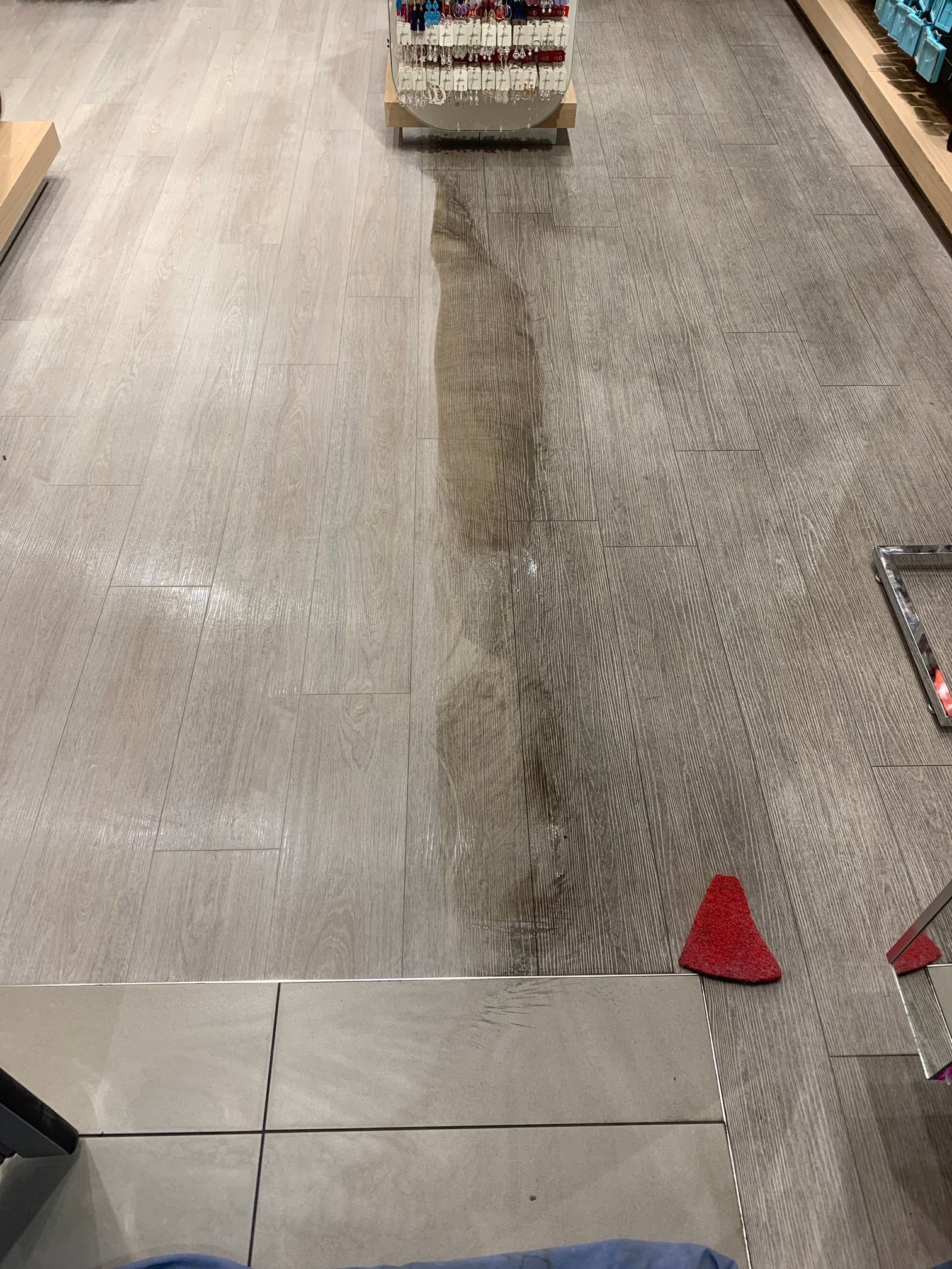 A person is cleaning the floor of a store with a mop.
