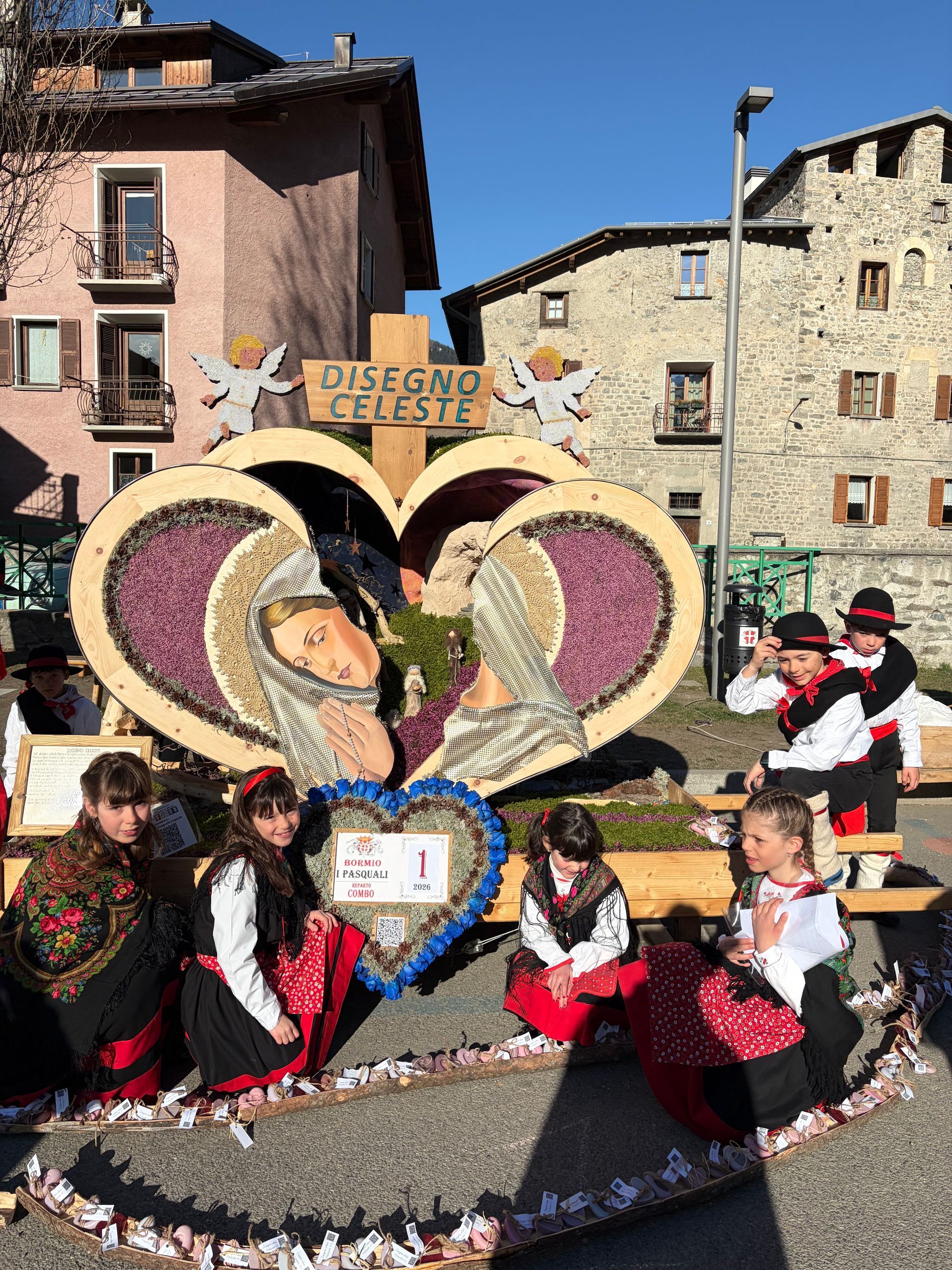 Un gruppo di persone è in piedi attorno a un tavolo su cui è raffigurato il modello di un villaggio.