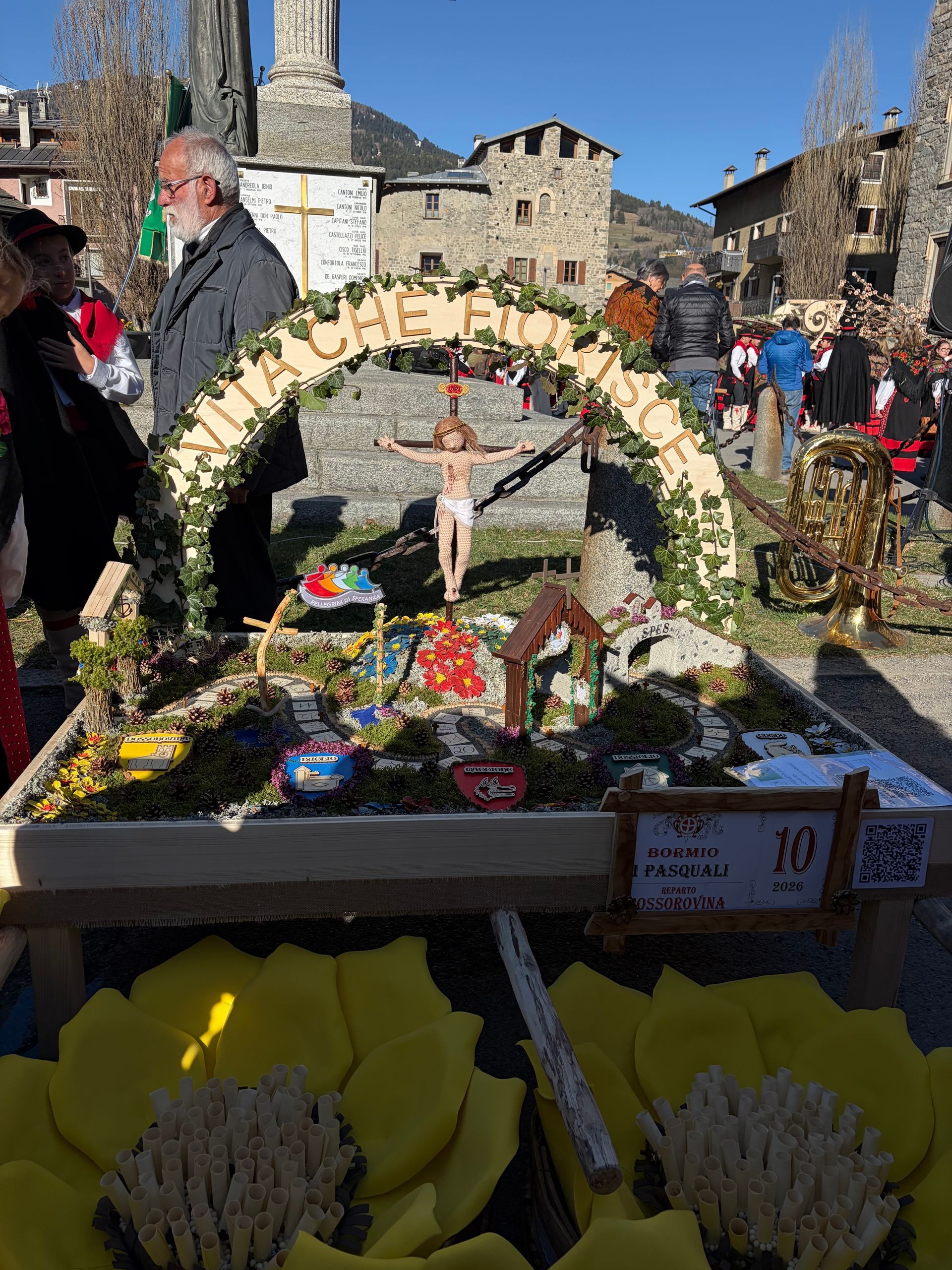 Un gruppo di persone è in piedi attorno a un tavolo con degli ombrelli sopra