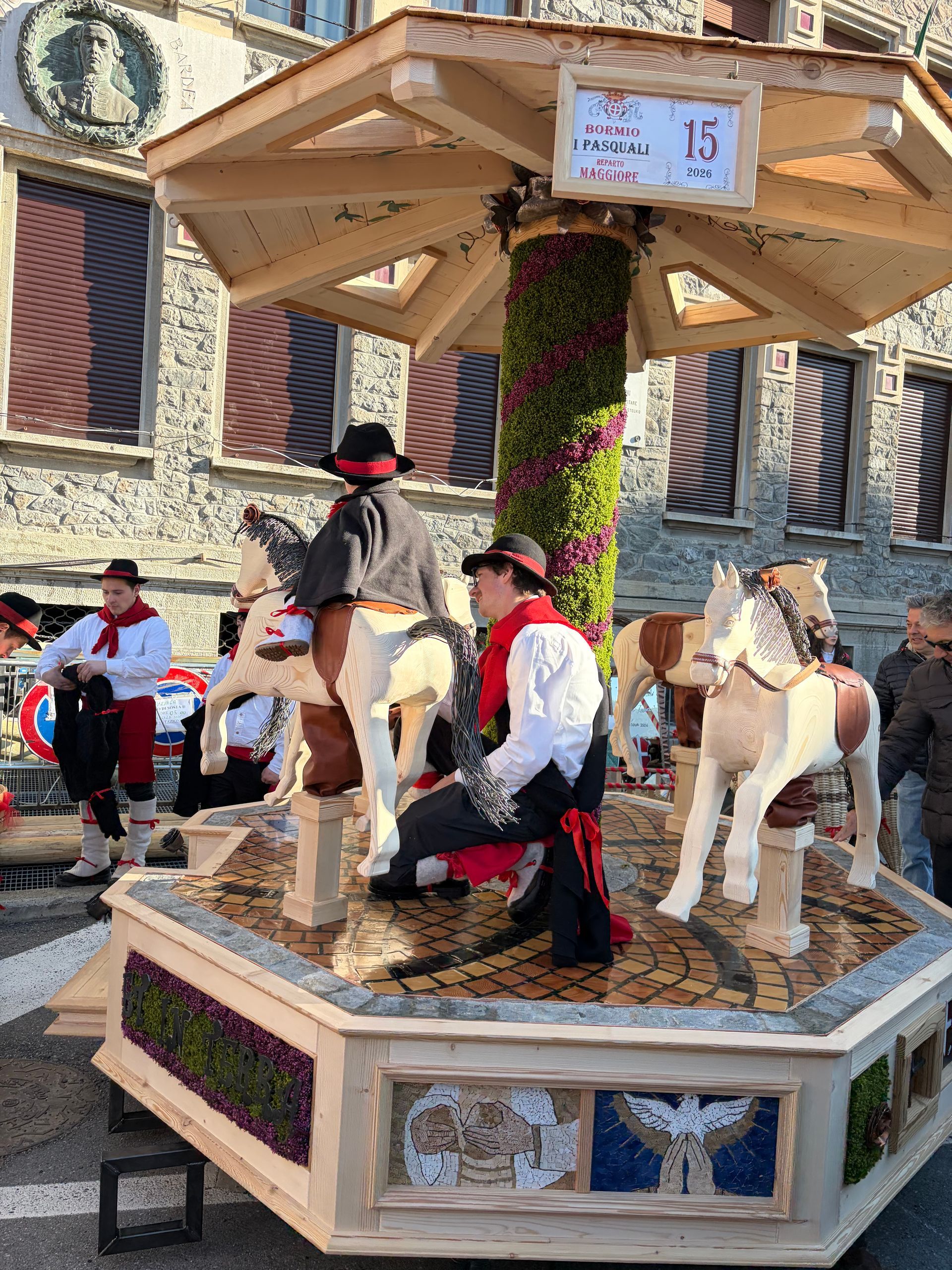 Un grande uovo fatto di fiori è appoggiato su una piattaforma di legno.