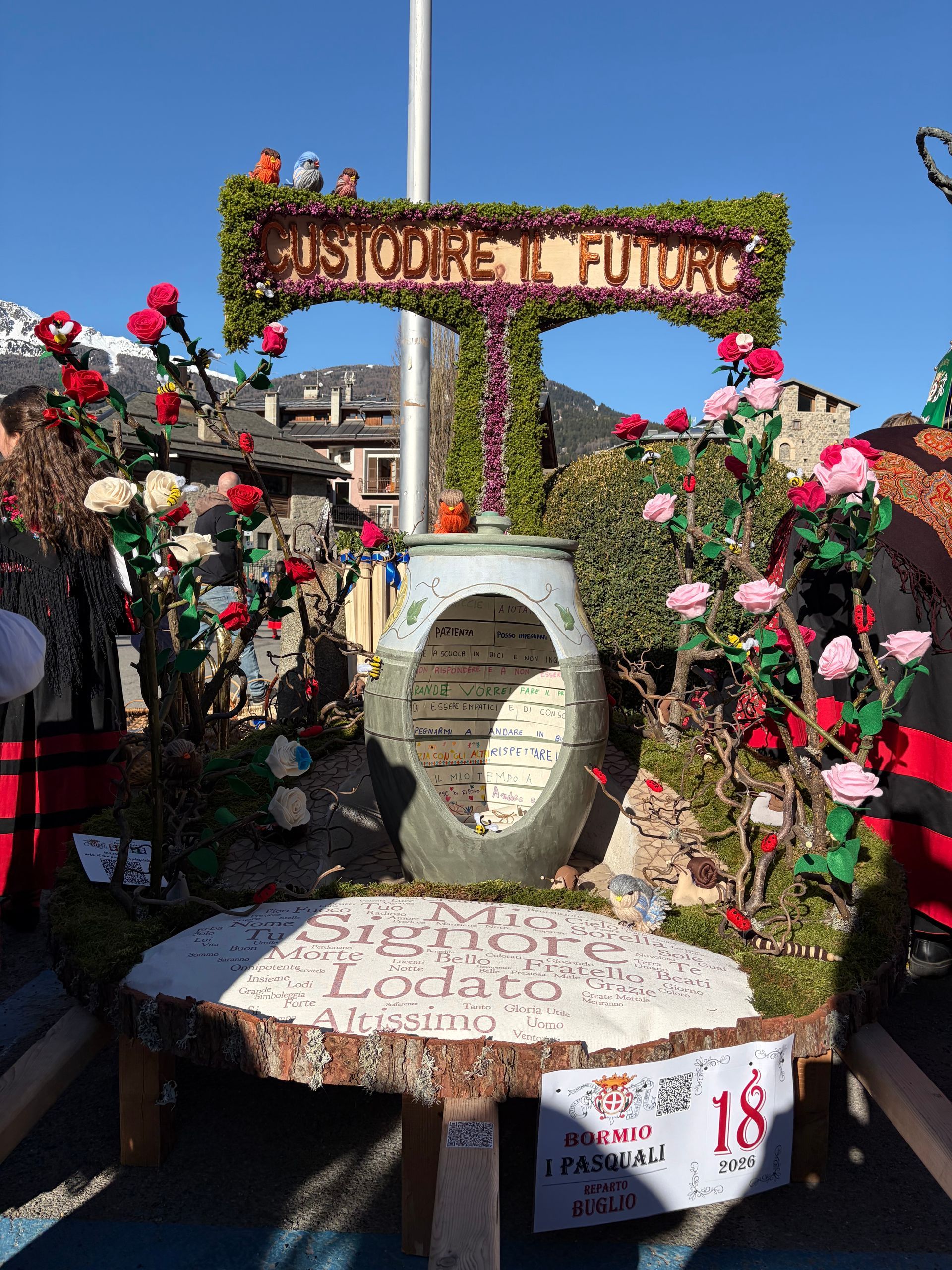 Un albero di Natale fatto di paglia è appoggiato a terra.