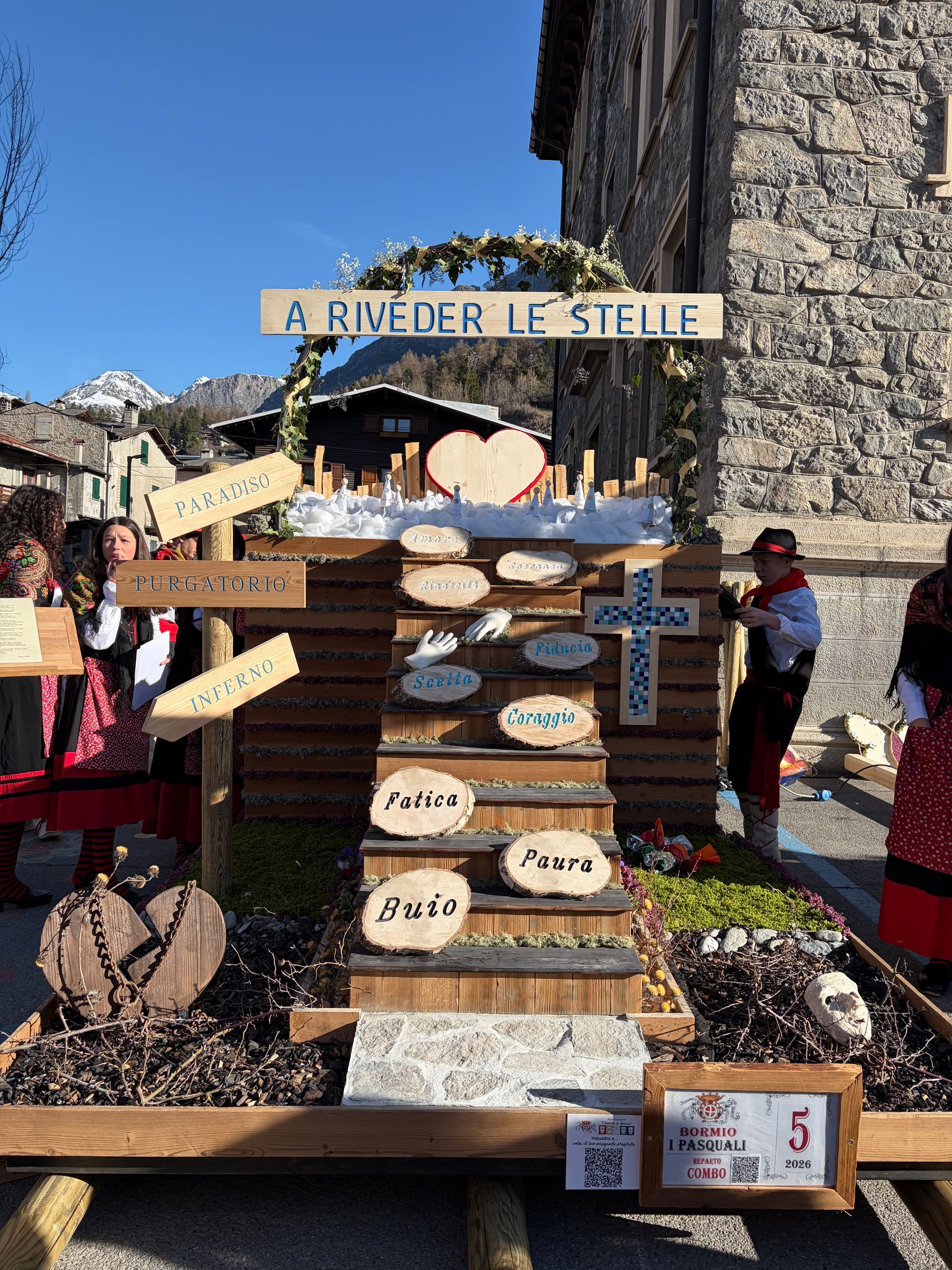 Un gruppo di persone è in piedi attorno a una grande scultura di legno.