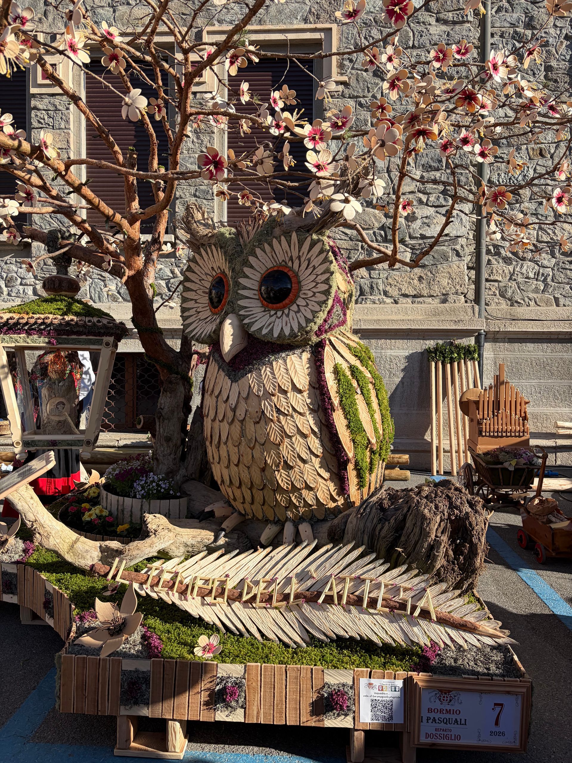 Un gruppo di persone è in piedi attorno a una esposizione di fiori e campanelli.