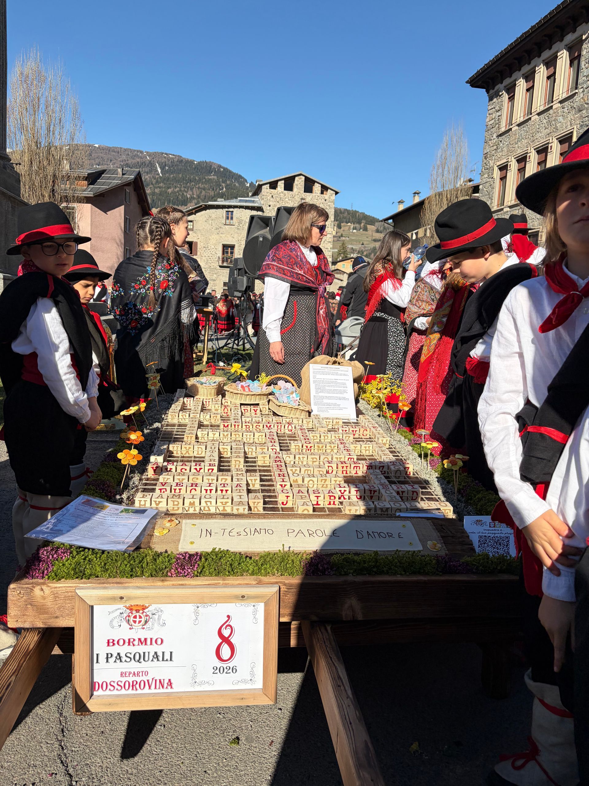 Un gruppo di persone è in piedi attorno a un tavolo con una statua sopra.