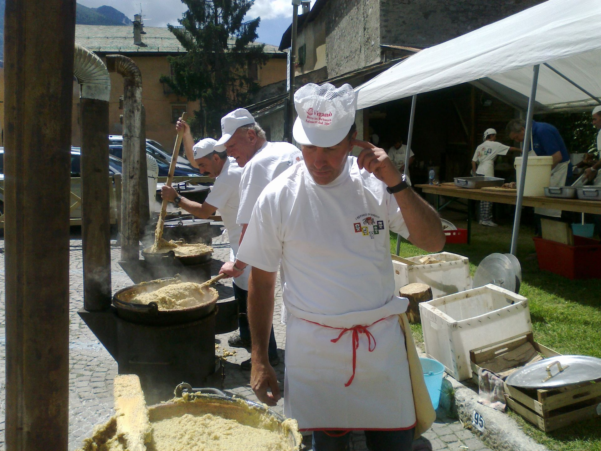 Un uomo che indossa un cappello da cuoco e un grembiule sta cucinando il cibo