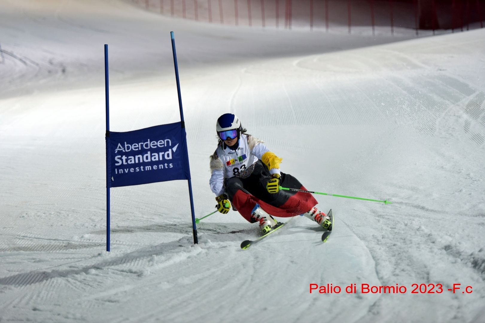 Una persona sta sciando lungo un pendio innevato accanto a un cartello che dice Aberdeen Standard