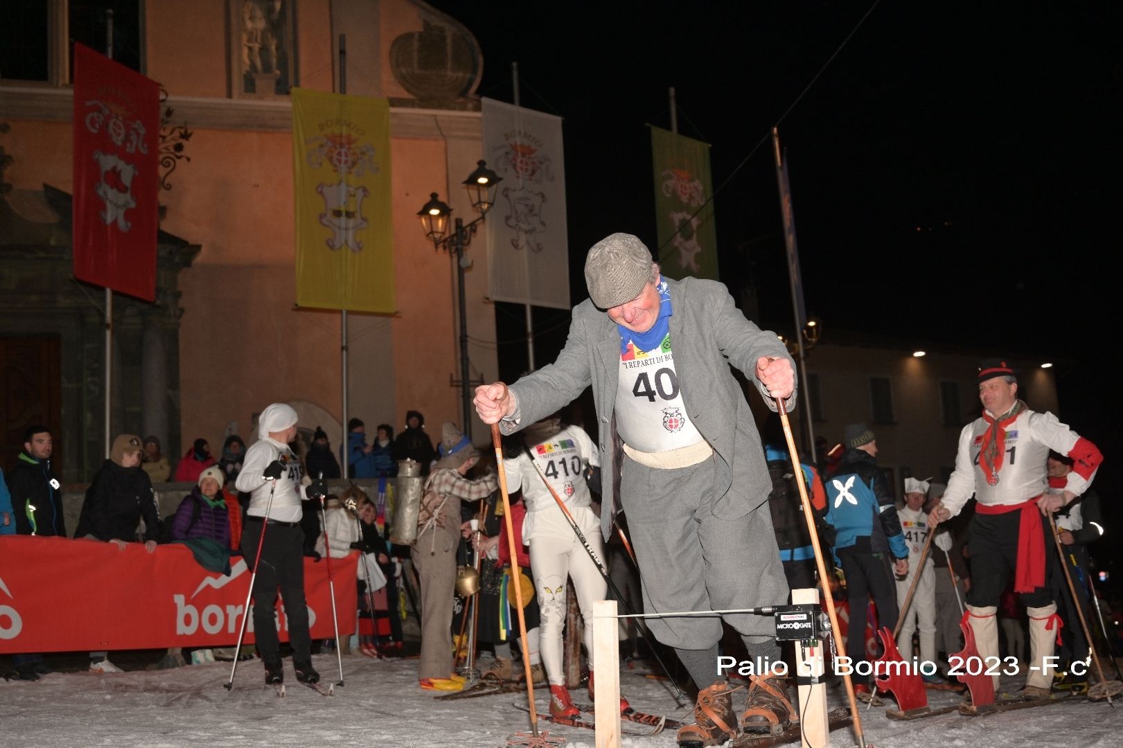 Un uomo in giacca e cravatta con il numero 40 sulla maglietta sta sciando sulla neve.