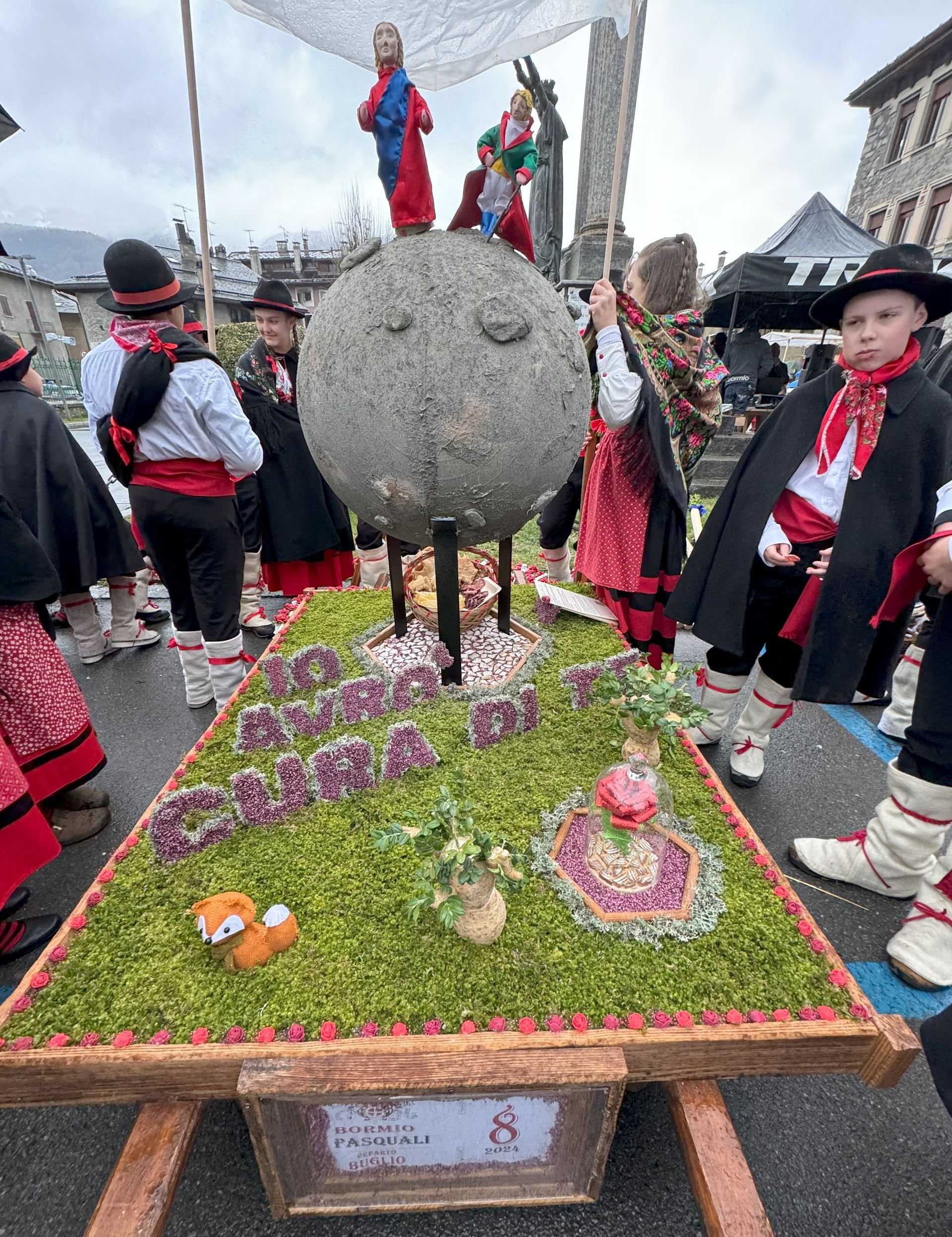 Un gruppo di persone è in piedi attorno a un tavolo su cui è posata una statua.