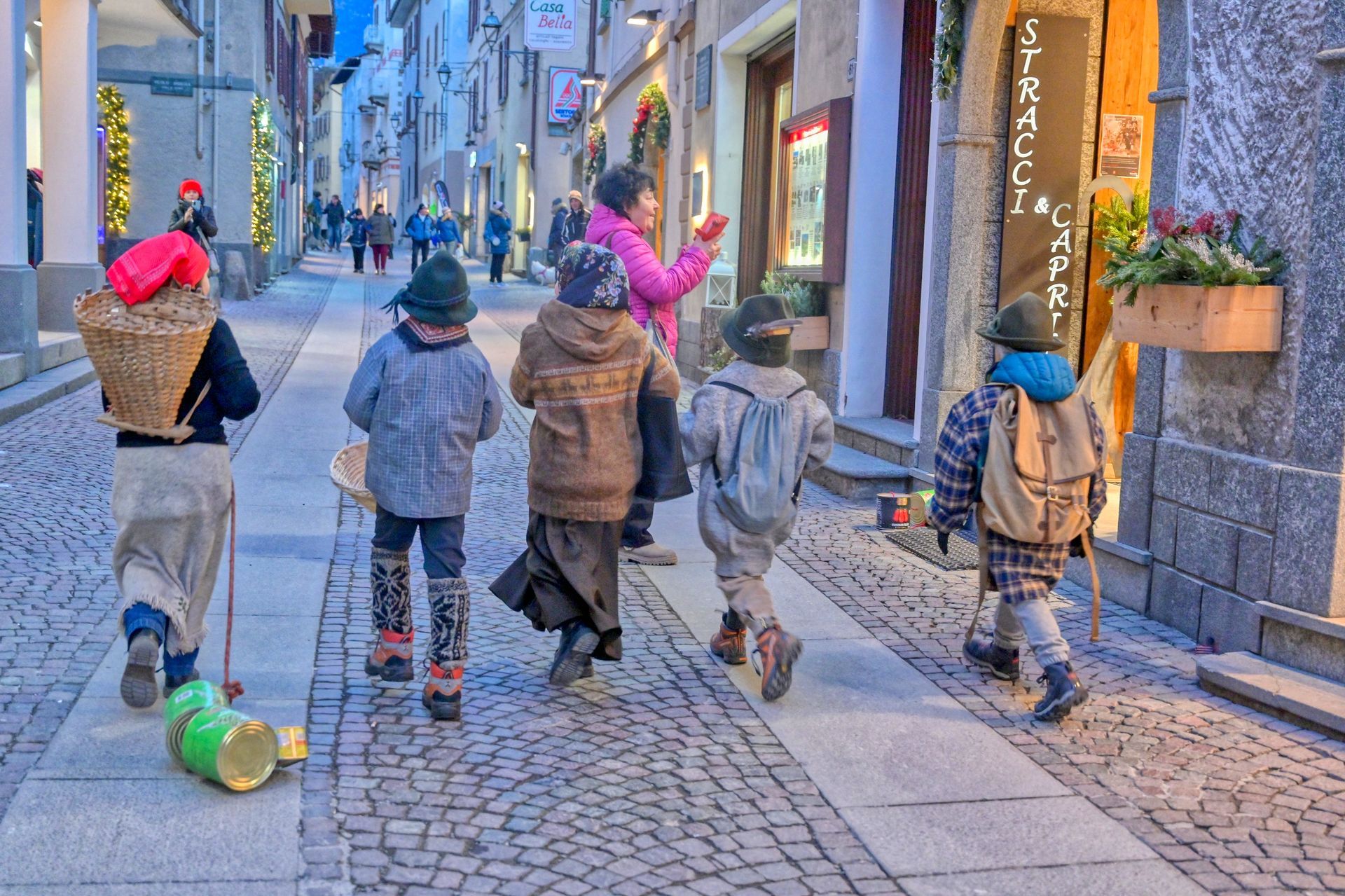 Un gruppo di bambini cammina lungo una strada acciottolata.