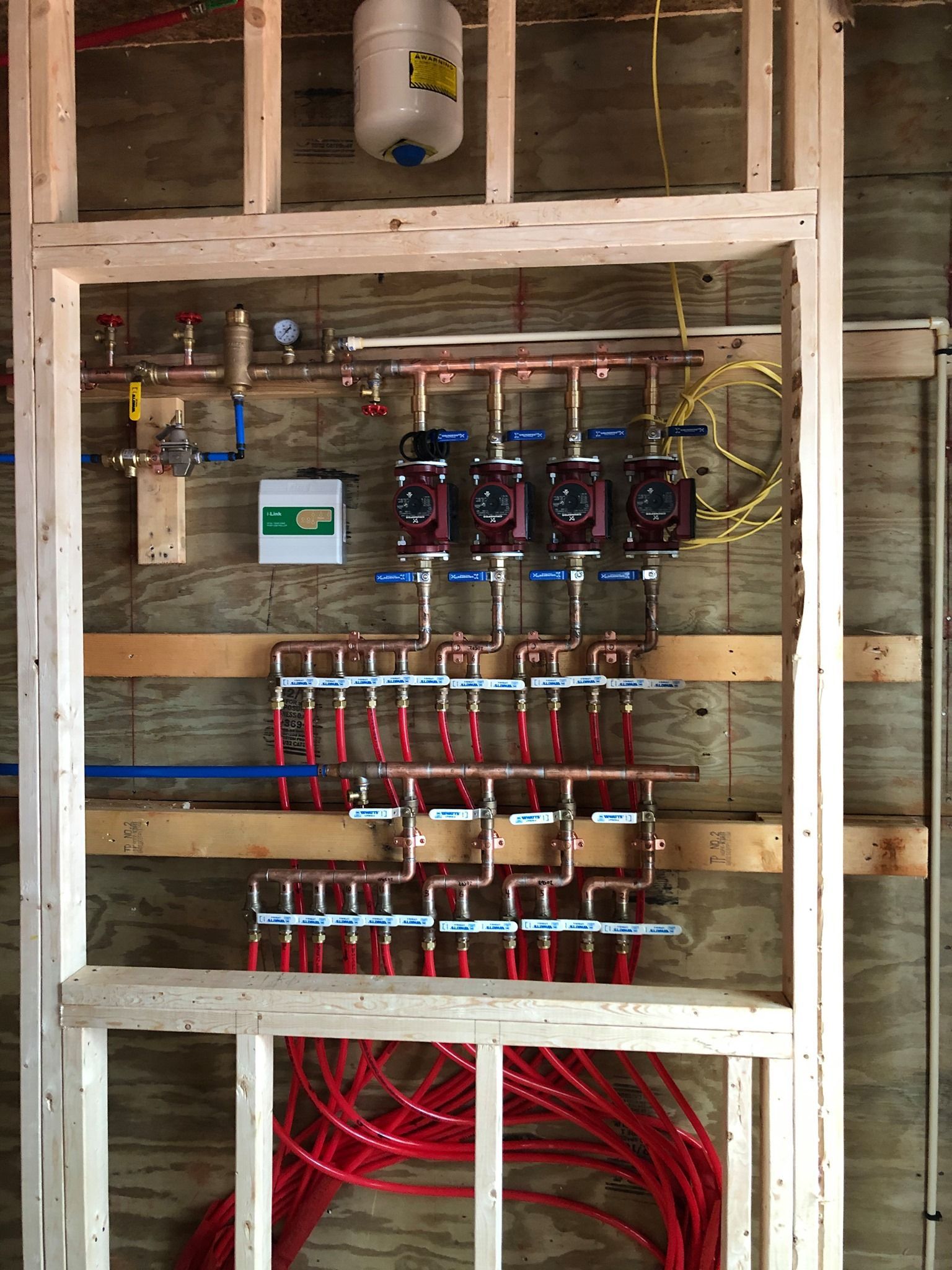 A wall with a bunch of pipes hanging from it.