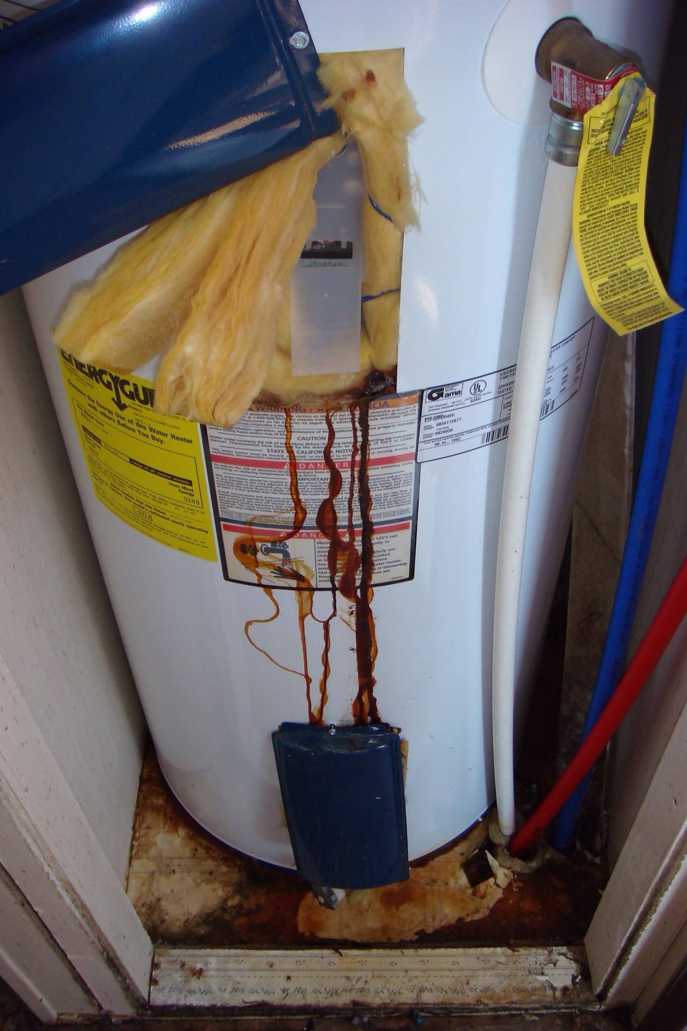 A water heater with a yellow sticker on it