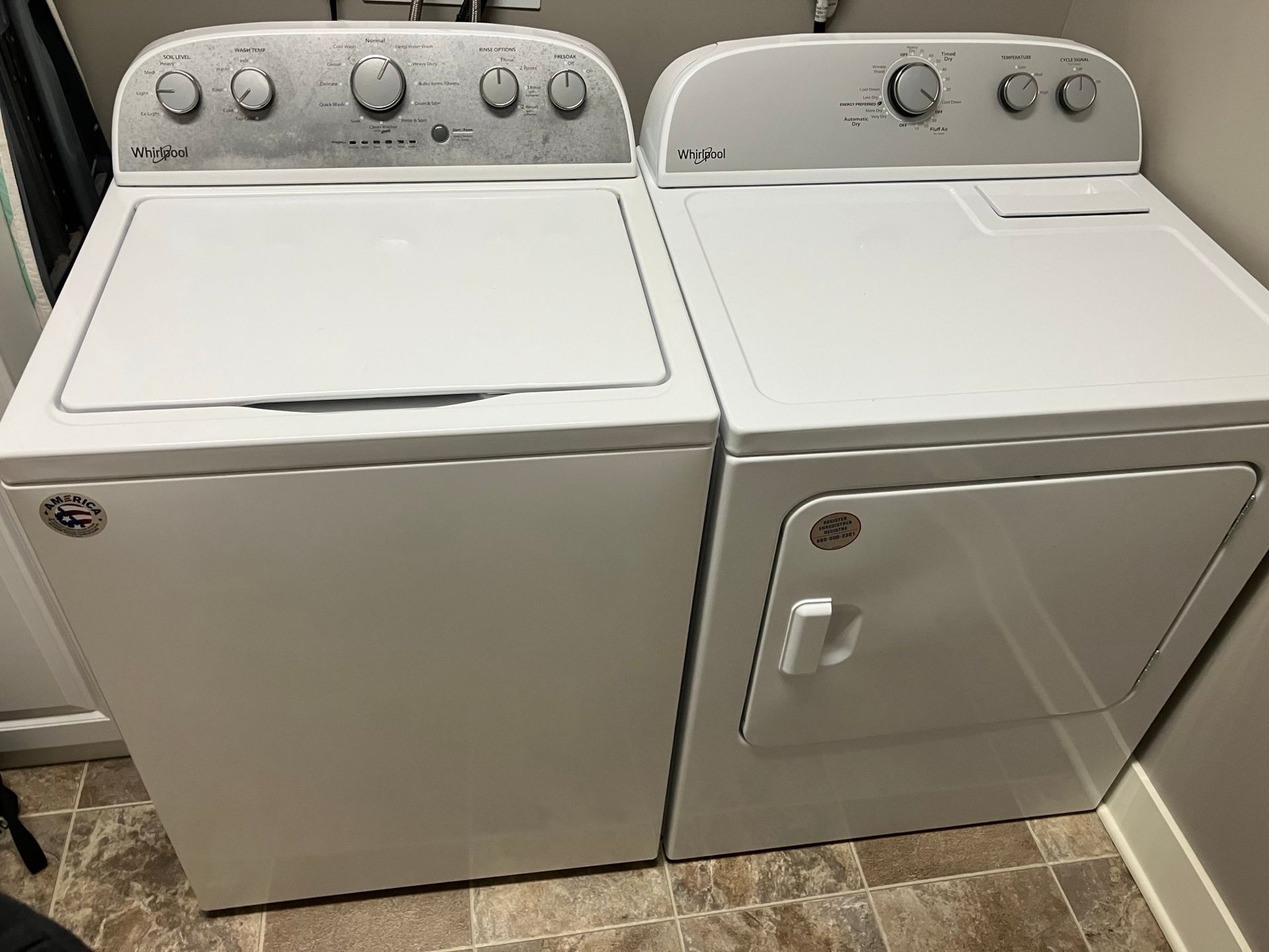 A white washer and dryer are sitting in a laundry room.