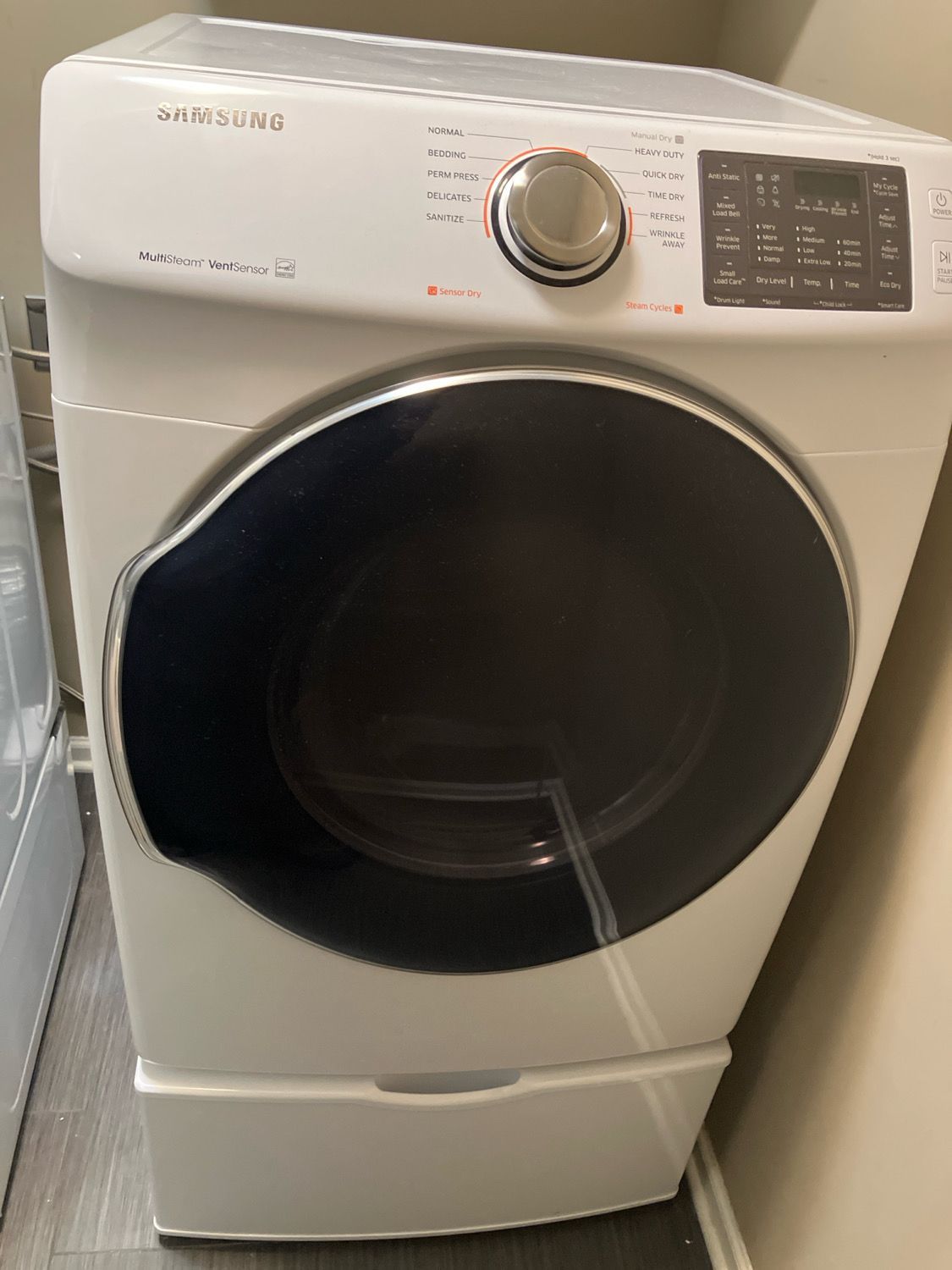 A white washing machine and dryer are sitting next to each other in a room.