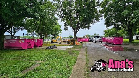 Park with pink food stalls and trees along a wet pathway after rain
