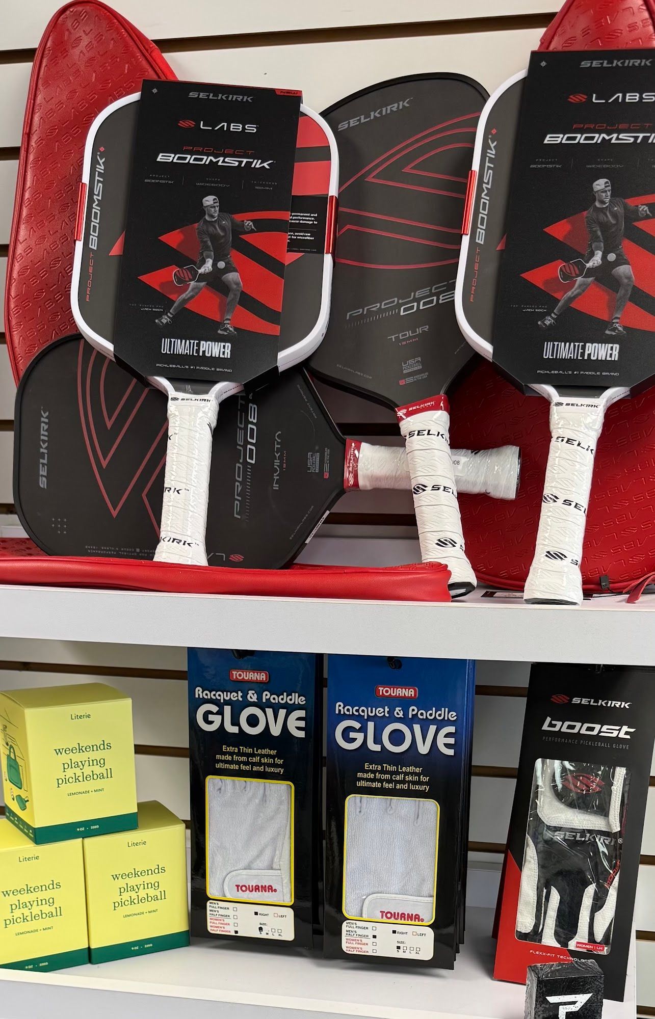 Assorted sporting goods and gloves displayed on store shelves, with red and black items in the center.