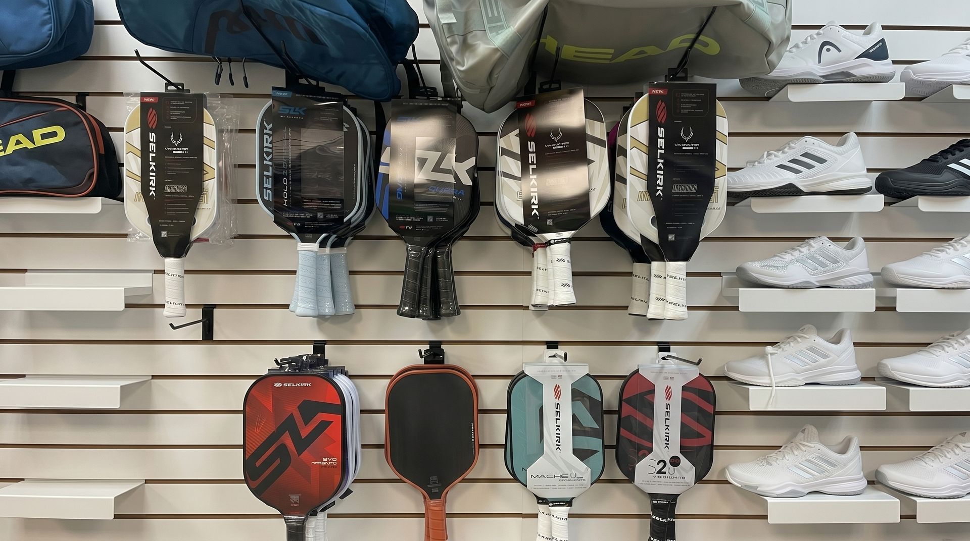 Shelving display of multiple colorful handheld devices and accessories hanging in a store aisle