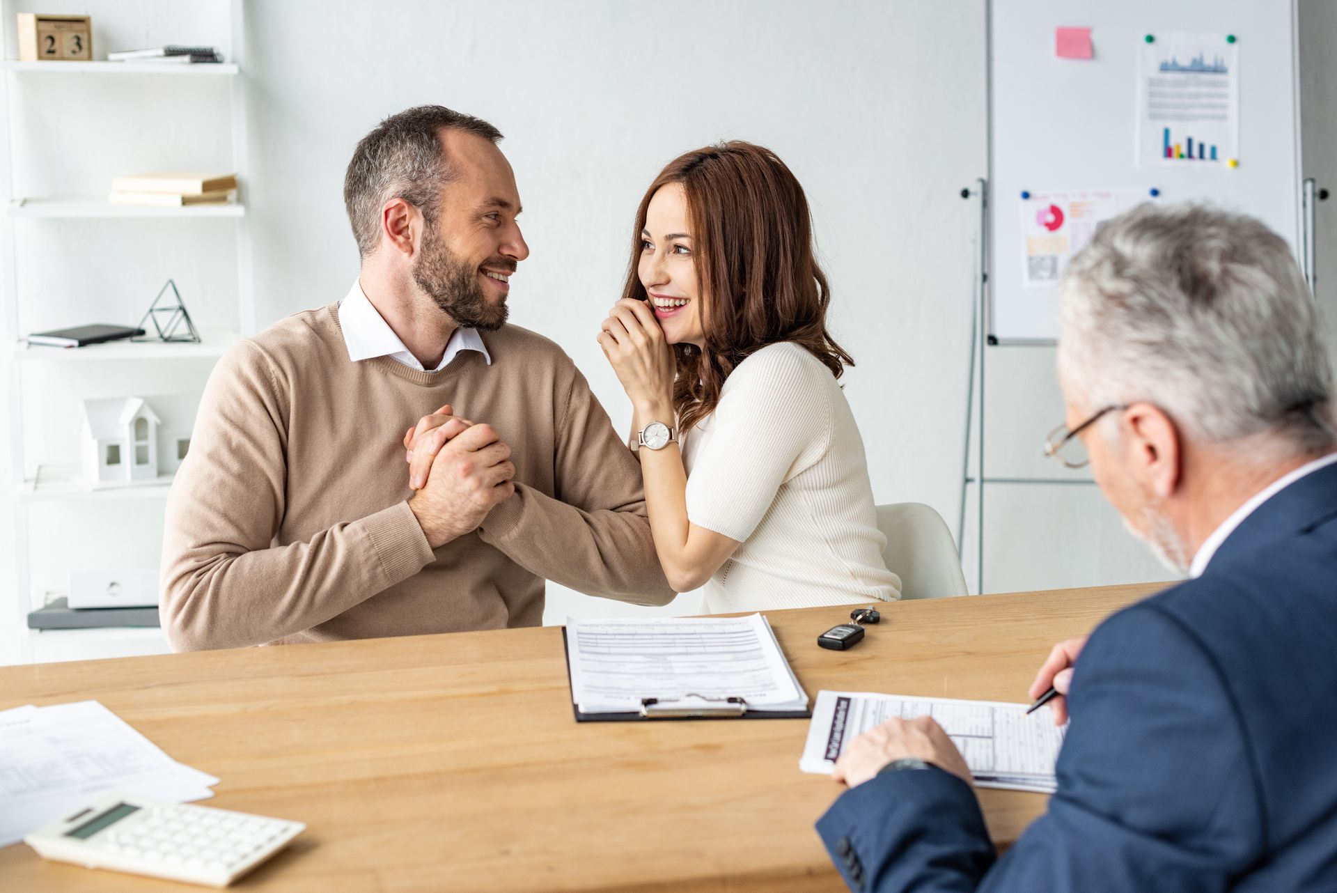 Couple speaking with a counselor across a table in a bright office