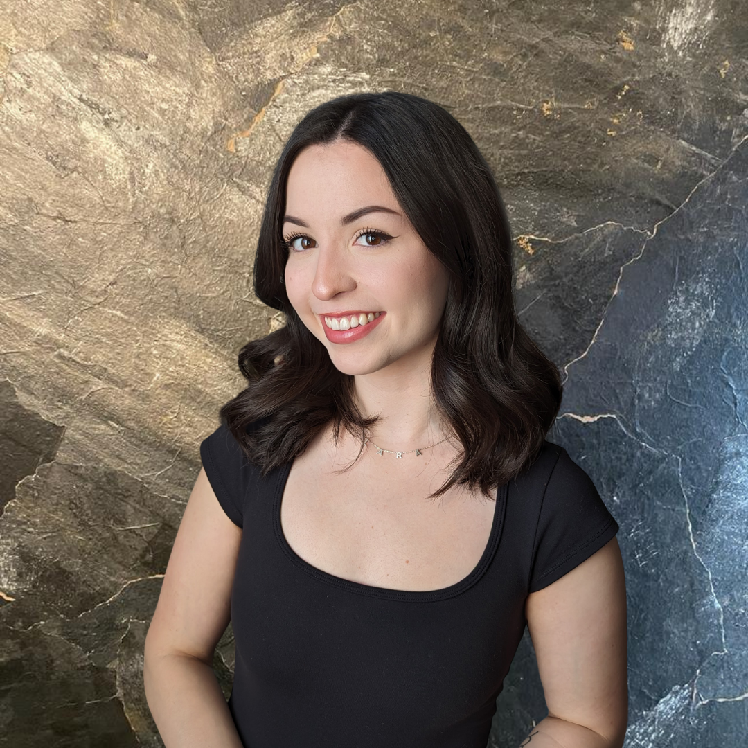 a woman in a black shirt smiles for the camera