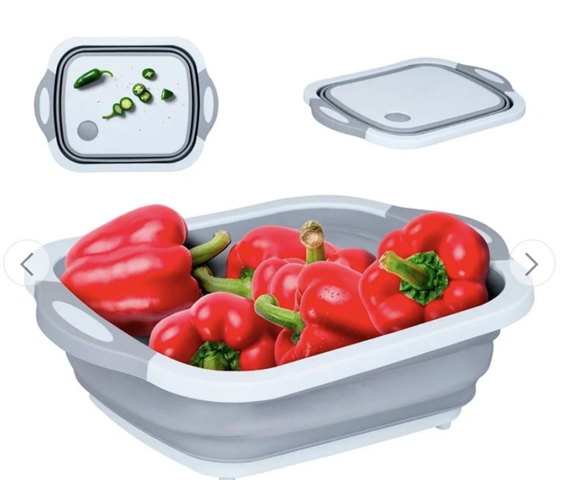 Colador gris plegable con pimientos rojos, una tabla de cortar blanca con pimientos verdes.